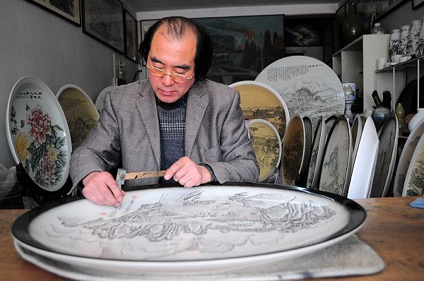 2013年3月6日，陶瓷雕刻绘画艺术家朱立民在陶瓷盘上雕刻作品。 (1).JPG