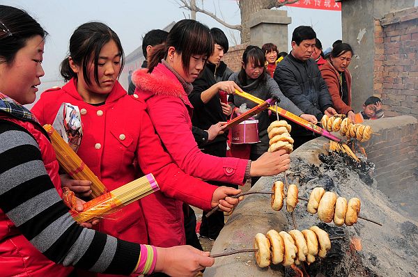 2013年3月16日，山东省茌平县韩屯镇罗屯村西北的鲁义姑庙会上，民众烤烧饼祈福求子。 (24).jpg