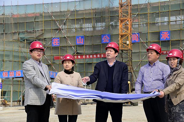 2014年3月24日，山东省茌平县实验幼儿园园长尹立业（中）在建设工地。
