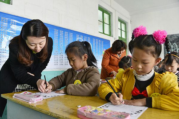 2014年3月25日，周楼小学小学生在吴海燕老师的指导下进行正确书写汉字。