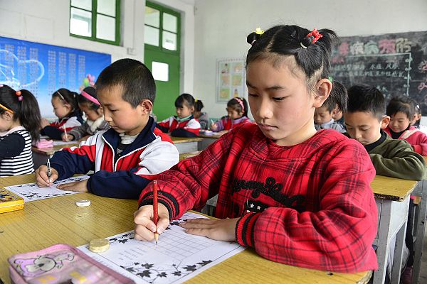 2014年3月25日，周楼小学小学生在老师的指导下进行正确书写汉字。 