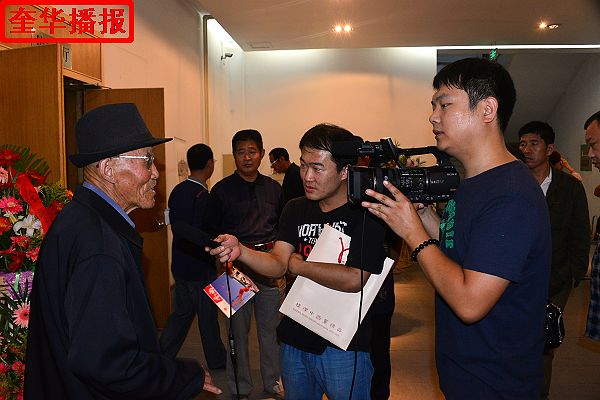 2014年9月29日，画家张宗源在中国（高唐）第九届书画博览会展厅现场接受媒体采访。