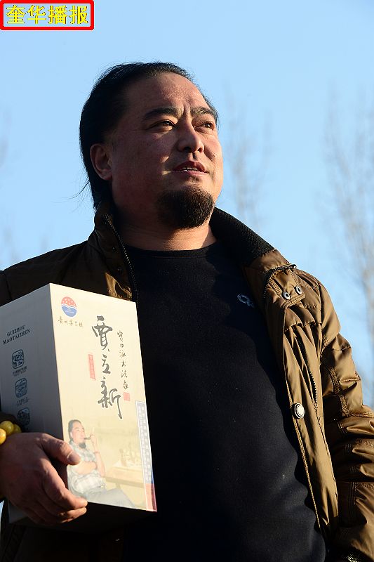 书法家贾立新与他定制的茅台镇出产的“贾立新酒”。