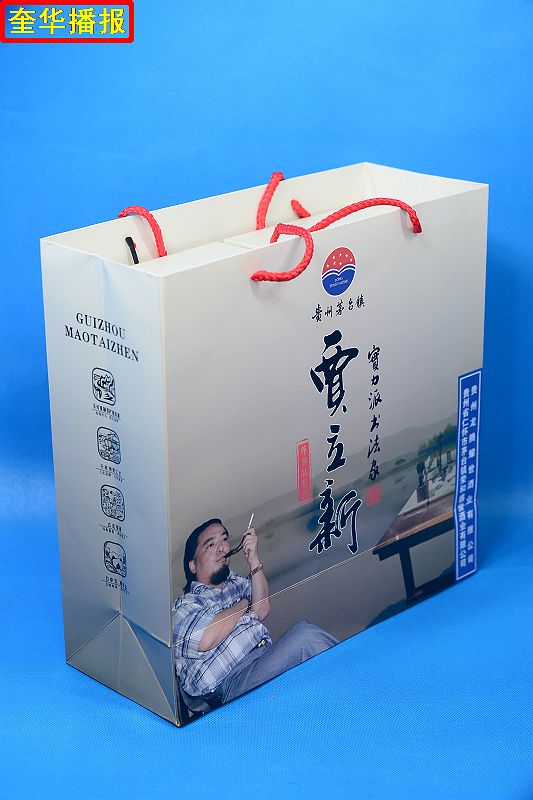书法家贾立新与他定制的茅台镇出产的“贾立新酒”。