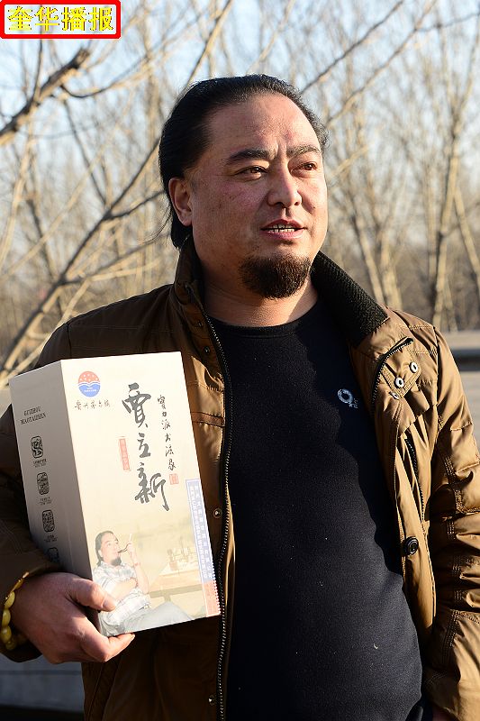 书法家贾立新与他定制的茅台镇出产的“贾立新酒”。